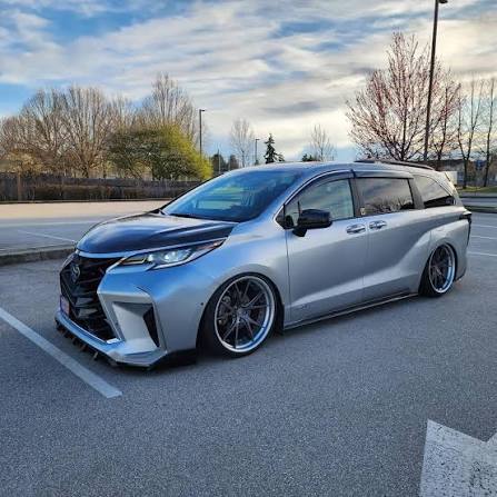 Silver Toyota Sienna with full body kit, lowered on multi-spoke wheels